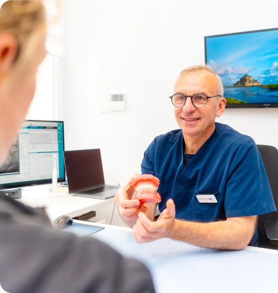Orthodontiste présentant un modèle dentaire au bureau de consultation